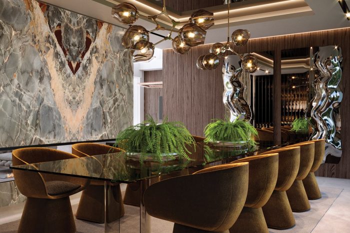 Formal Dining area. The onyx wall, floating over a natural fire, the walnut panelling and the subtle lighting bring warmth (both literally & metaphorically) to this opulent space.