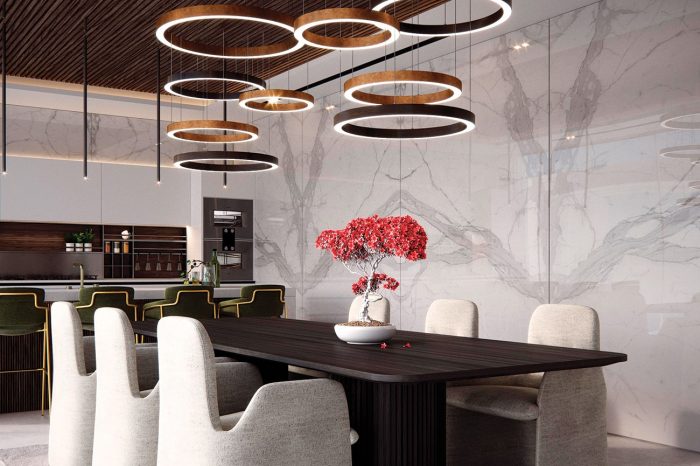 A Kitchen that looks like a dining room you can cook in, its large circular Henge lamps overlooking a dark wood table and light velvet chairs.