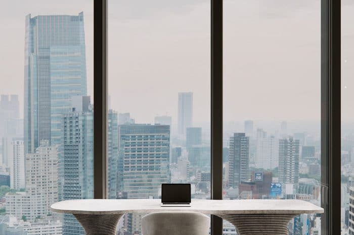 An organic, stone sculptural desk looks over the view of the city