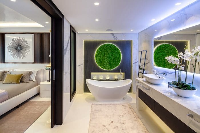 A free standing bath sits under a living green circle of moss.