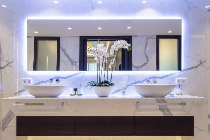 Double sinks with structure in same material as walls - smoked eucalyptus and Calcutta stone.